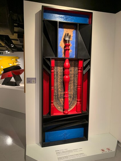 A modern art installation with geometric shapes and a central red sculpture. 3