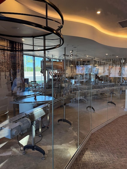 A modern industrial setting with machinery, glass barriers, and a curved ceiling structure. 3