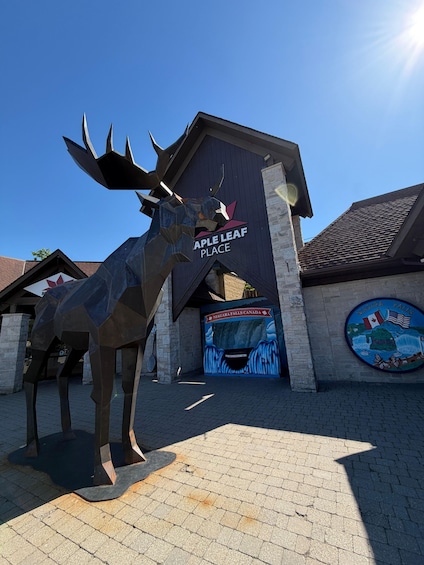 A large moose sculpture in front of a building with 'Maple Leaf Place' and 'Niagara Falls Canada' signage. 4