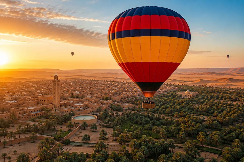 A hot air balloon over a city with palm trees and a tower. 1