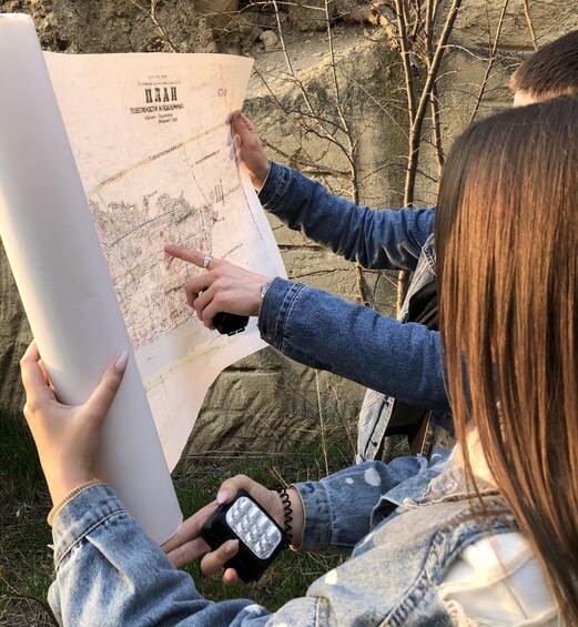 Two people examining a large map outdoors. 4