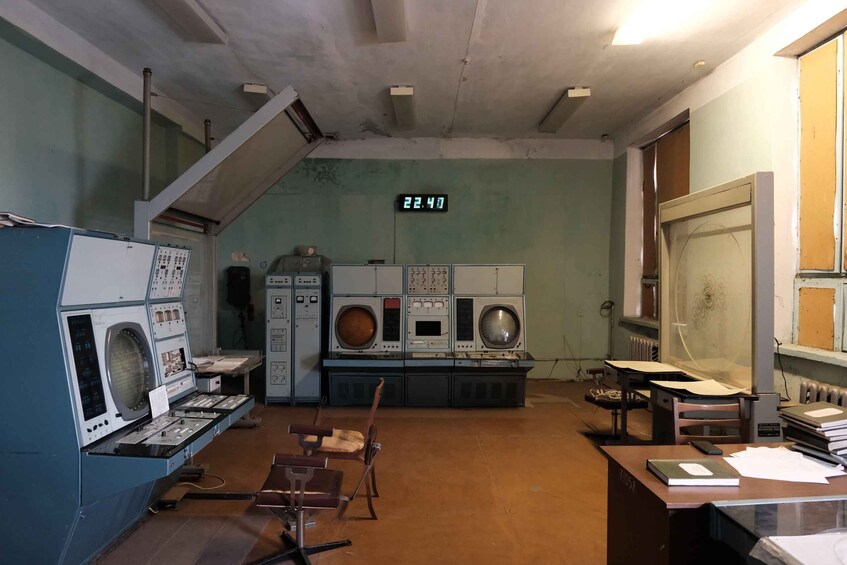 A room with industrial equipment, including a large washing machine, control panels, and a digital clock displaying 22:47. 3