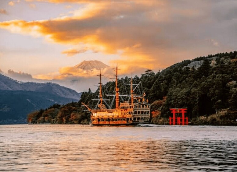 A ship on a calm lake with a mountain in the background. 1