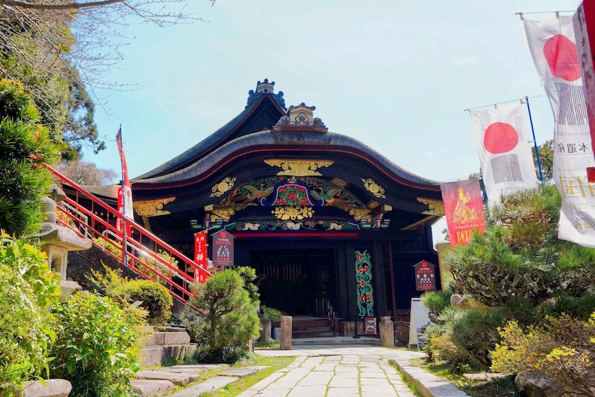 A traditional Japanese building with ornate decorations and a red staircase leading up to the entrance. 4