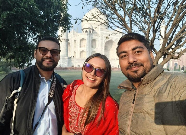 Three people in front of the Taj Mahal. 3