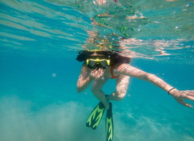 A person snorkeling underwater with fins and goggles. 2
