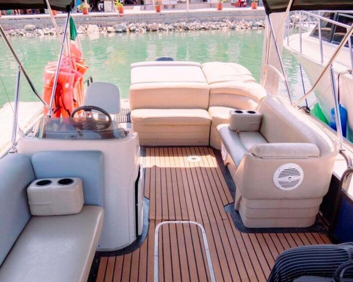 A boat's deck with seating and a steering wheel. 3