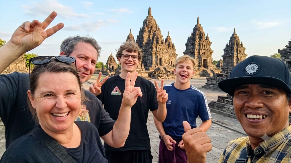 A group of people posing in front of ancient temple ruins. 5