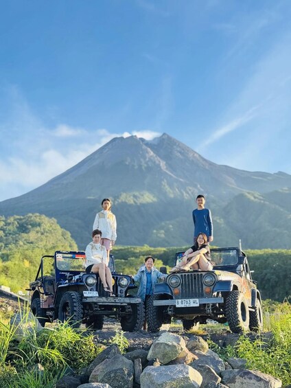 A group of people on a vehicle with a mountain in the background. 5