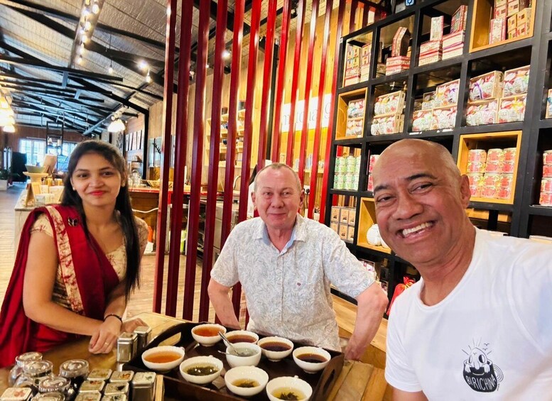 A person serving tea in a restaurant with shelves of packaged goods in the background. 1