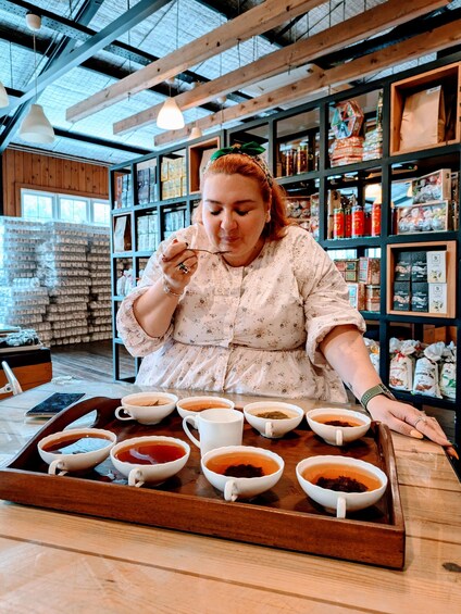 A person at a coffee shop with a tray of various cups of coffee. 5