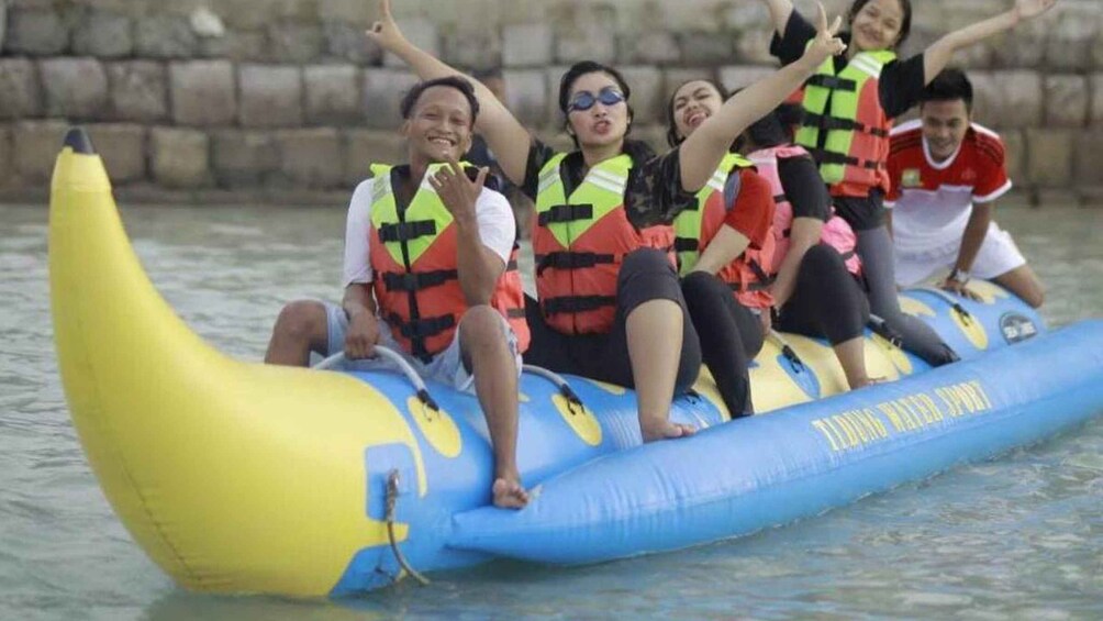 People on a banana-shaped raft in water. 5