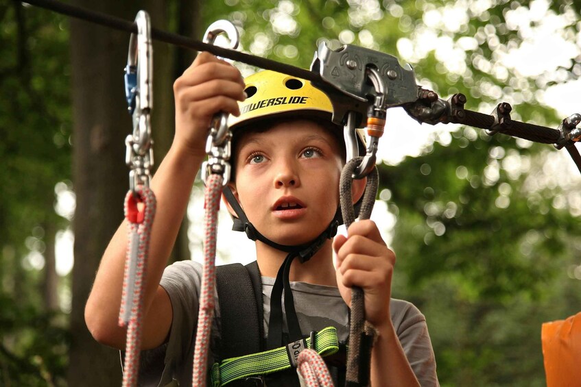 A person engaged in a zip-lining activity, wearing a helmet and harness. 2