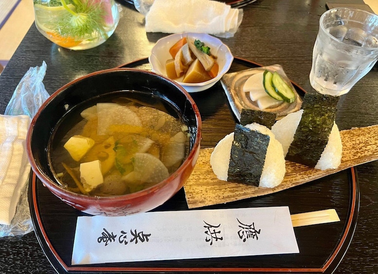 A traditional Japanese meal with a bowl of soup, sushi, and a drink. 3