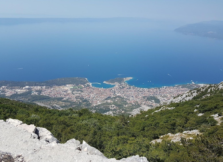 A coastal cityscape with a view of the sea and a mountainous backdrop. 1