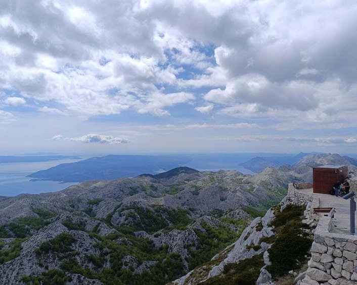 A mountainous landscape with a stone structure and a distant body of water. 5
