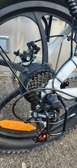 A bicycle's rear wheel with a chain, derailleur, and brake caliper. 3