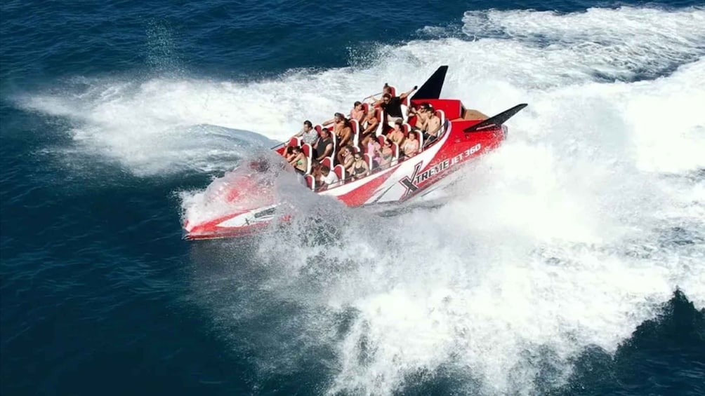 A speedboat with passengers, creating a large wake in the water. 1