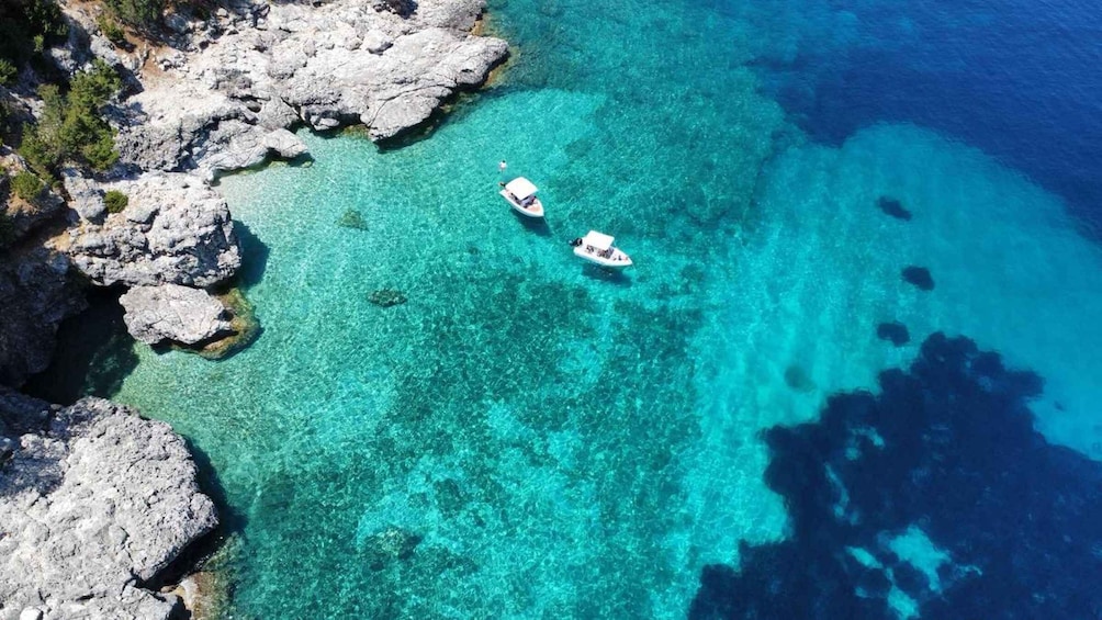 Two boats on clear turquoise waters near rocky coastlines. 3