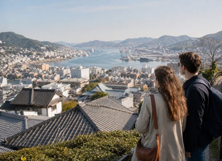 A couple overlooking a coastal cityscape with traditional buildings and a view of the sea. 5
