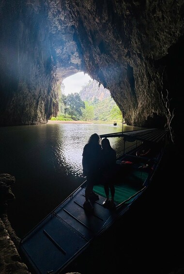 A cave with a water body inside, a hammock, and a boat. 1