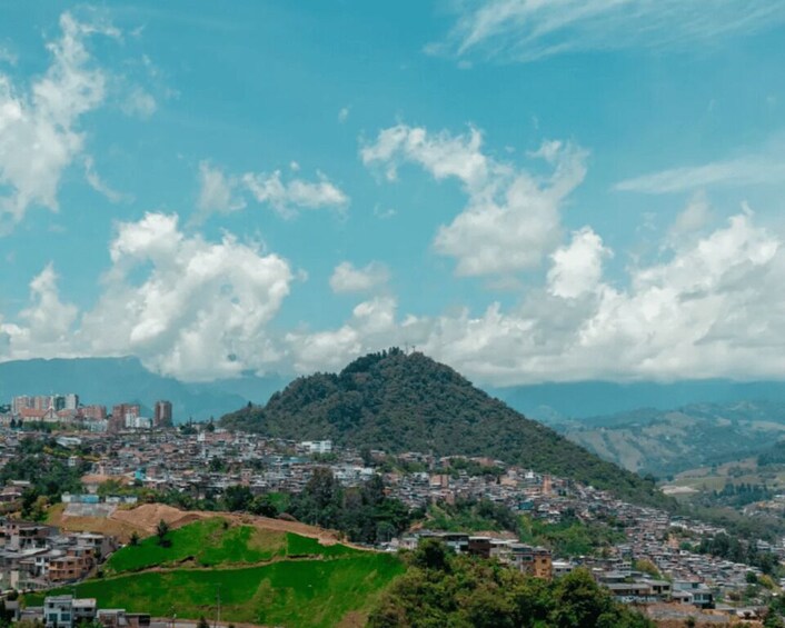 A cityscape with a hill in the background and a clear blue sky. 2