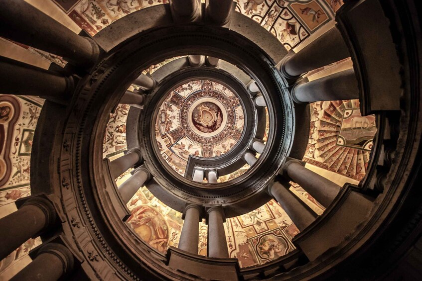A grand spiral staircase with ornate columns and a detailed ceiling fresco. 3