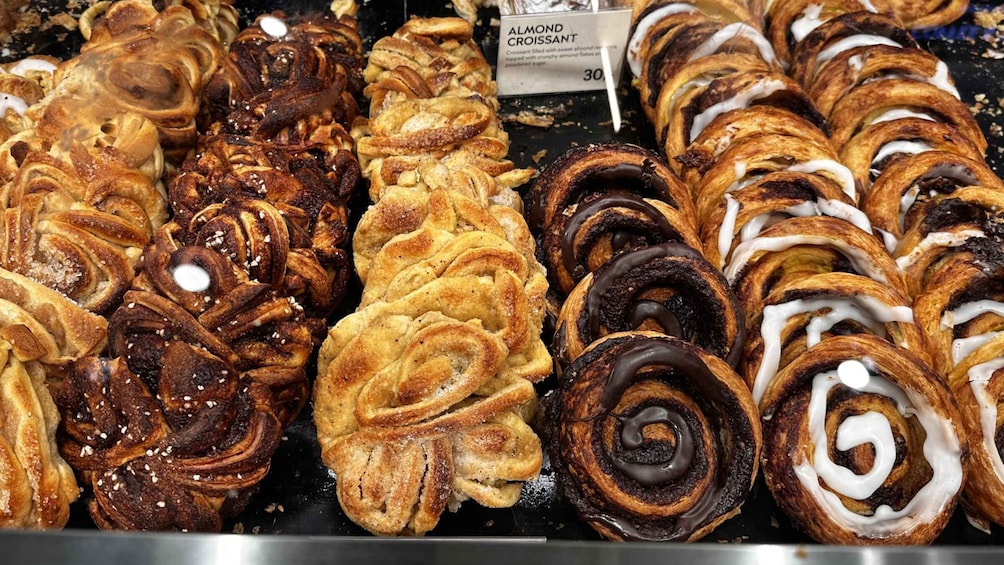 A variety of pastries including almond croissants and cinnamon rolls. 5