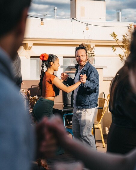 A group of people dancing outdoors with string lights in the background. 5