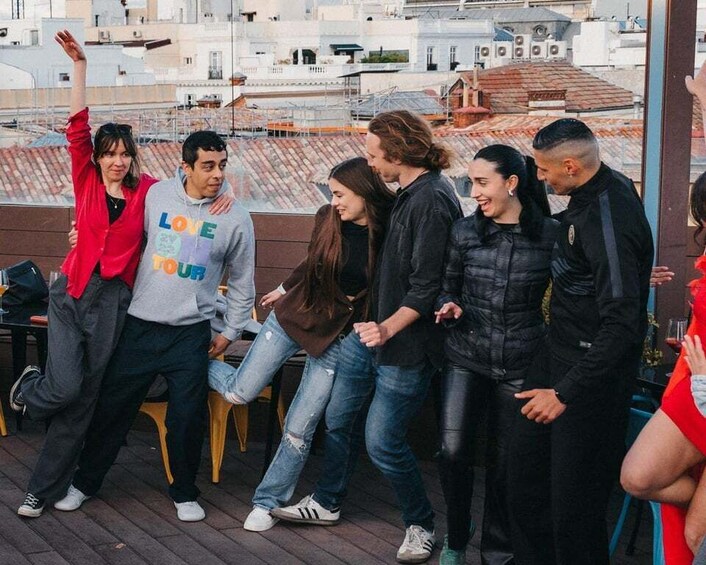 A group of people on a rooftop terrace with a cityscape in the background. 2
