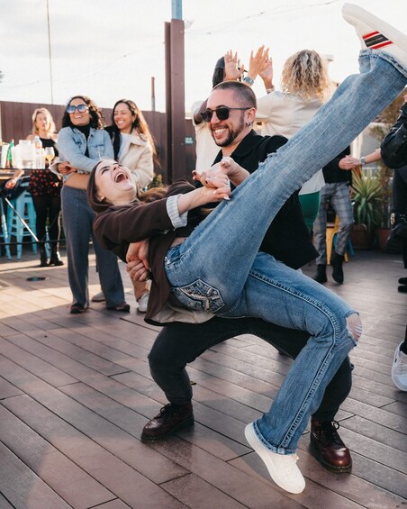A person being lifted by another, with onlookers in the background. 3