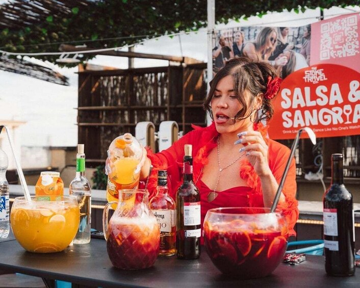 A person at a bar with various drinks and a sign reading 'SALSA & Sangria'. 1