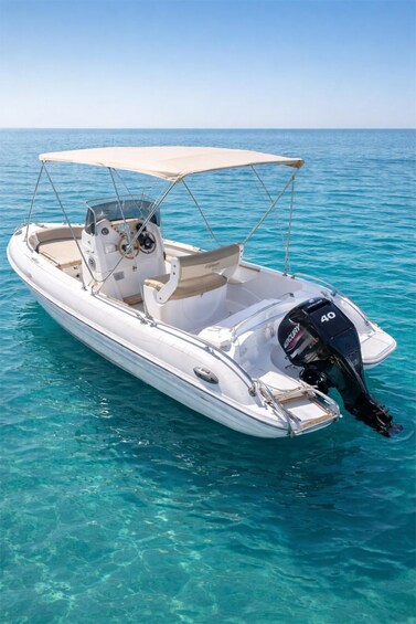 A white motorboat with a canopy, a steering wheel, and a 40-horsepower motor, floating on clear turquoise water. 5