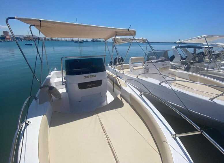 A marina with several boats docked, a clear sky, and a calm sea. 4