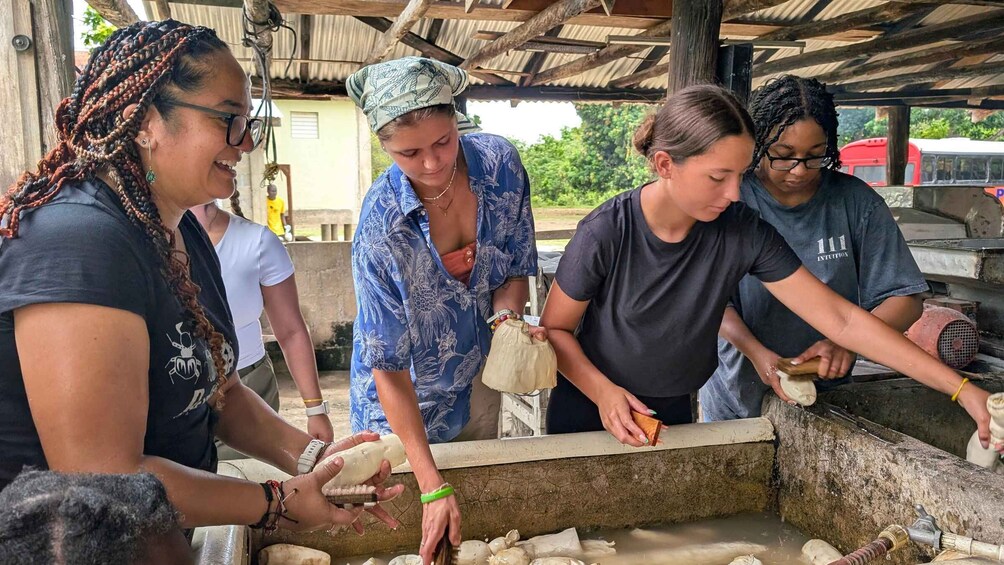 A group of people engaged in food preparation under a makeshift shelter. 5