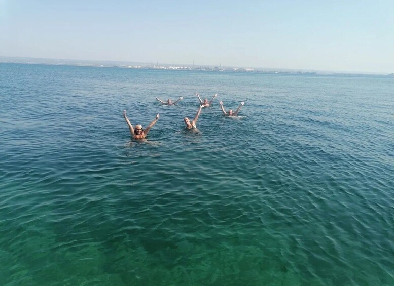 People swimming in a body of water with a distant shoreline. 2