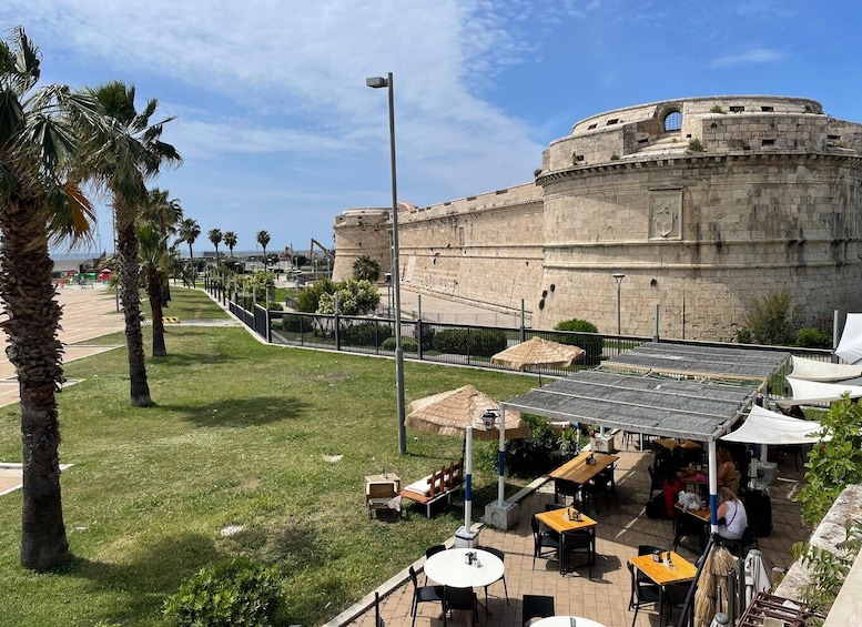 A coastal fortification with a café area in the foreground. 4