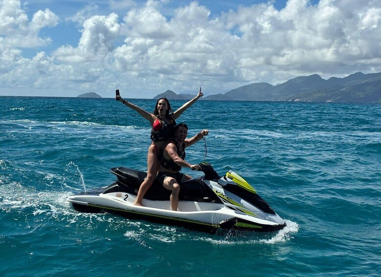 A person jet-skiing with another on a clear day over the ocean. 3