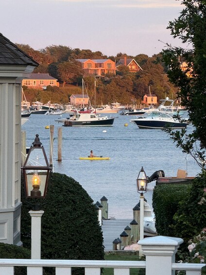 A marina with boats, a person kayaking, and buildings in the background. 2