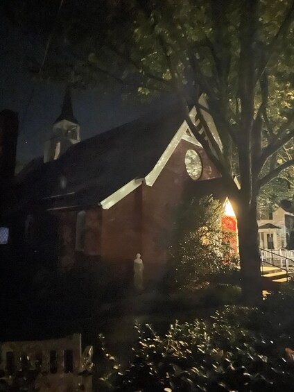 A church with a clock tower at night, illuminated by lights. 4