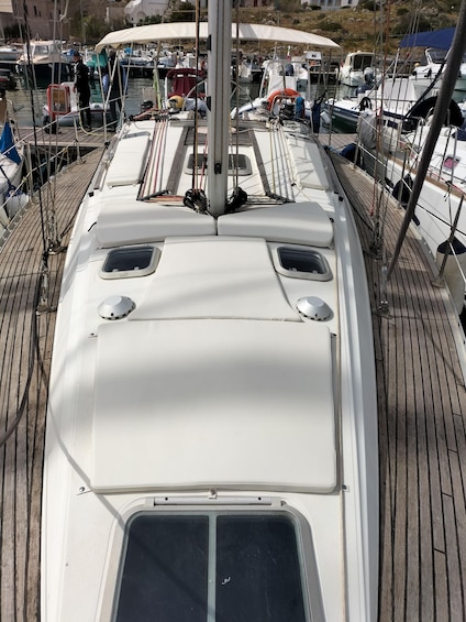 A boat's deck with a white cabin, a steering wheel, and a mast. 3
