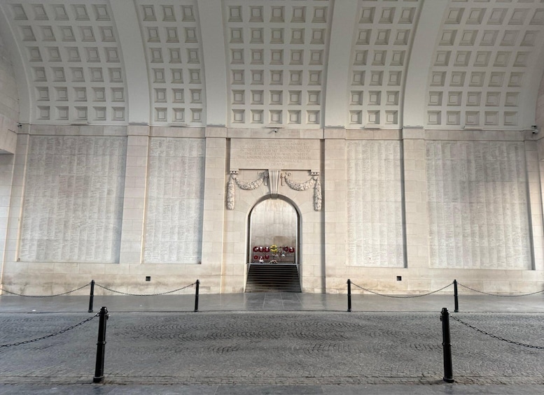 A large, solemn memorial with engraved names, a central archway, and a chain barrier in front. 4