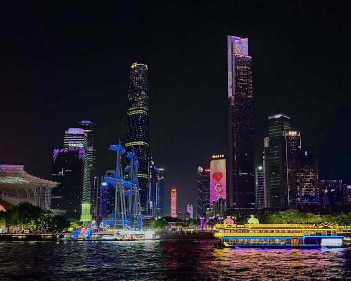 A nighttime cityscape with illuminated skyscrapers and a river with a boat. 3