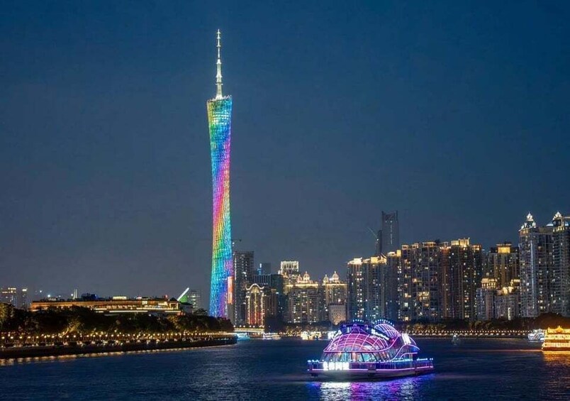 A brightly lit skyscraper with a rainbow color scheme, a body of water with a boat, and a city skyline in the background. 4