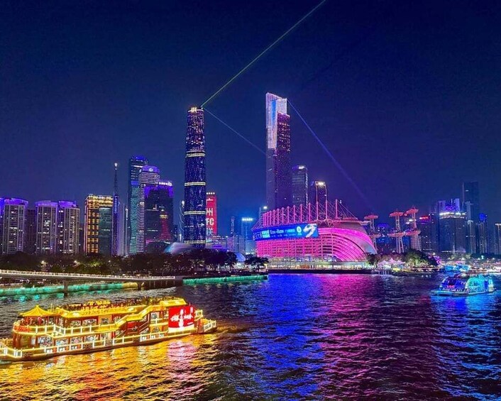 A nighttime cityscape with illuminated skyscrapers and a river with a boat. 2