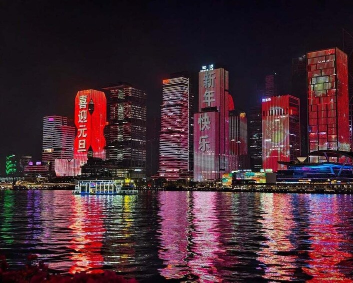 A nighttime cityscape with illuminated buildings reflecting on the water. 5