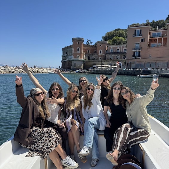 A group of people on a boat with a historic building in the background. 1