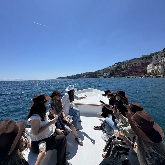 A group of people on a boat with a coastal town in the background. 5