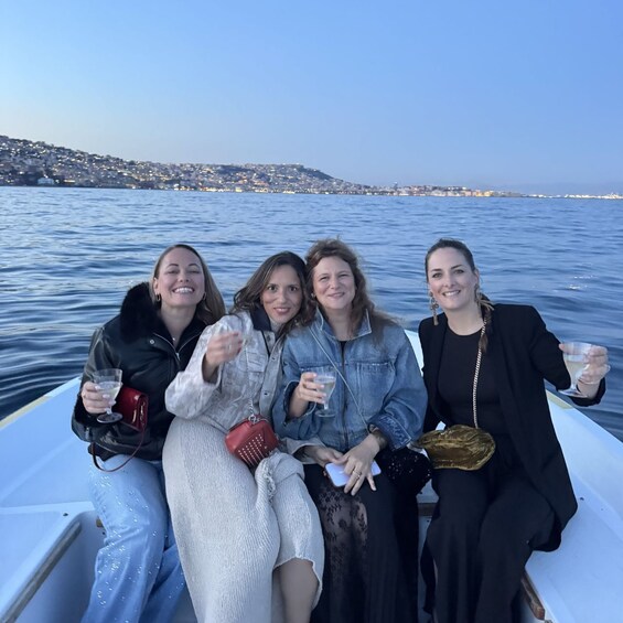 Four people on a boat with a cityscape in the background. 3