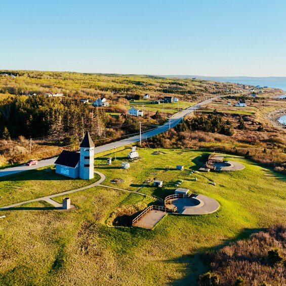 A coastal village with a prominent church, a winding road, and scattered houses. 2